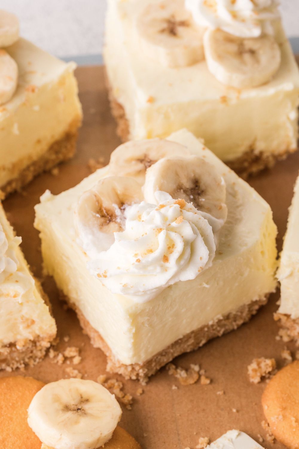 overhead look of sliced No Bake Banana Pudding Cheesecake Bars placed on table with some crumbs around the table 