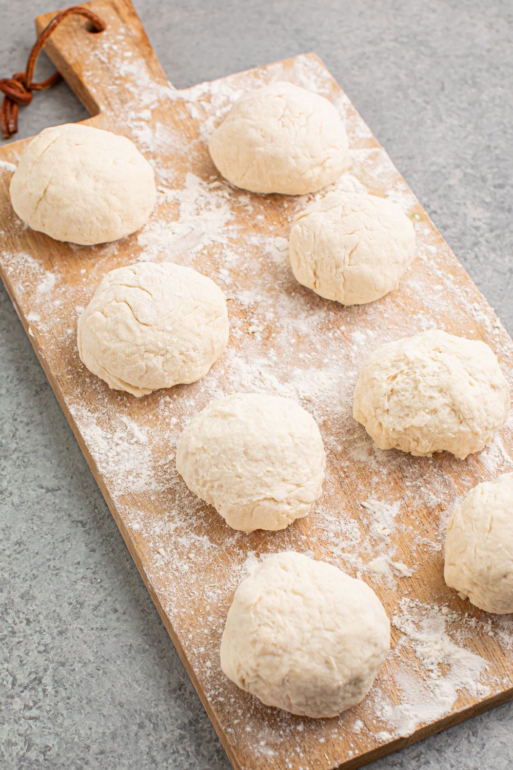 raw dough balls on cutting board on table for 2 Ingredient Dinner Rolls
