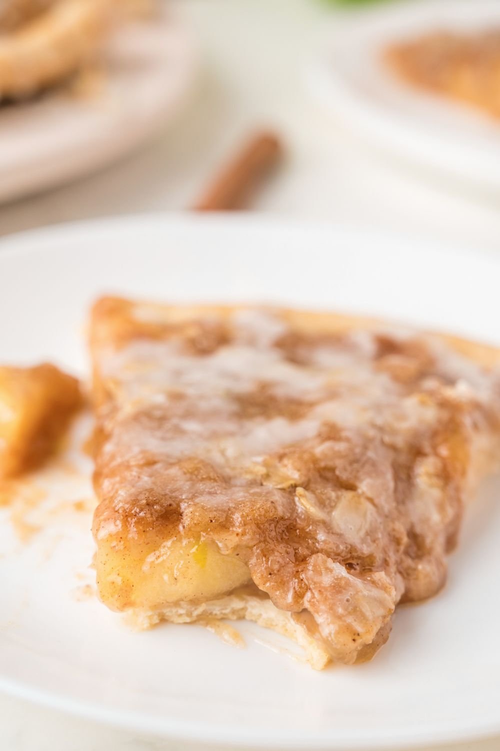 bite taken out of a slice of Apple Pie Pizza on plate on table 