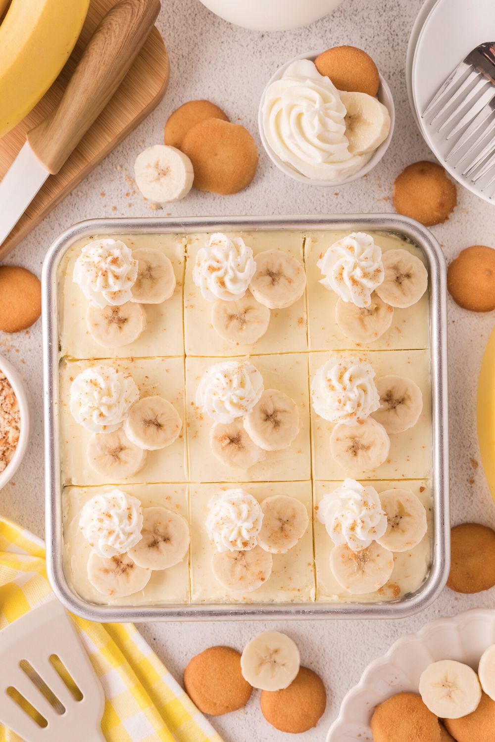 assembled and decorated No Bake Banana Pudding Cheesecake Bars in pan on table 