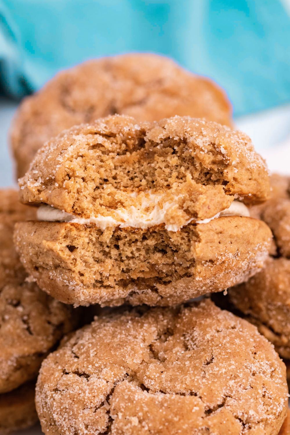 Apple Cider Whoopie Pies stacked on table with one that has a bite taken out of it 