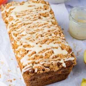 Apple Cinnamon Loaf Cake on the table with a jar that had glaze sitting next to it