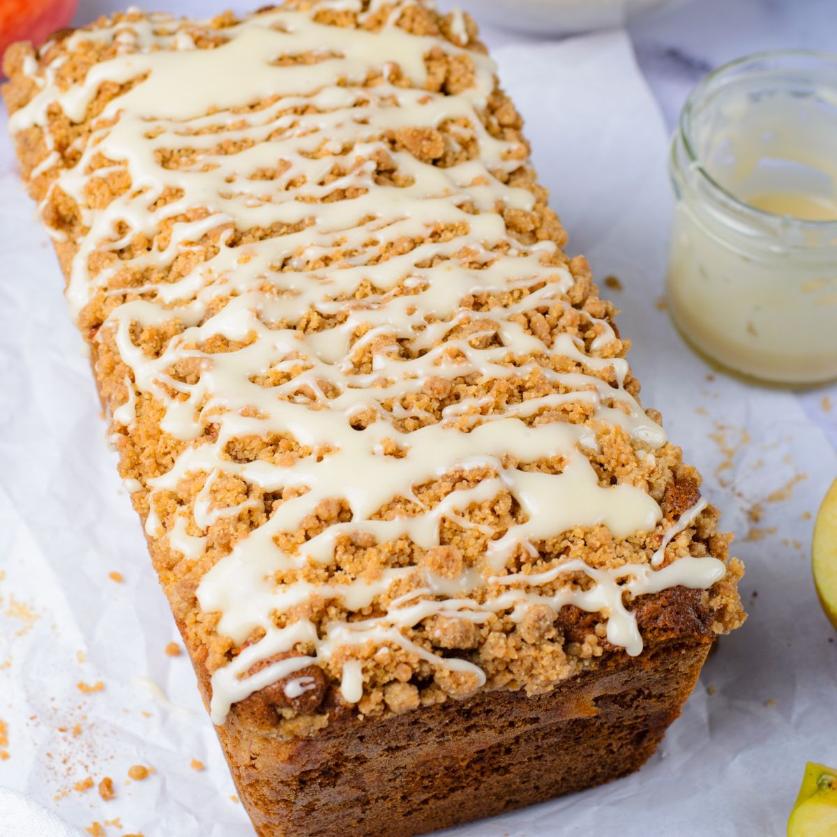 Apple Cinnamon Loaf Cake on the table with a jar that had glaze sitting next to it 