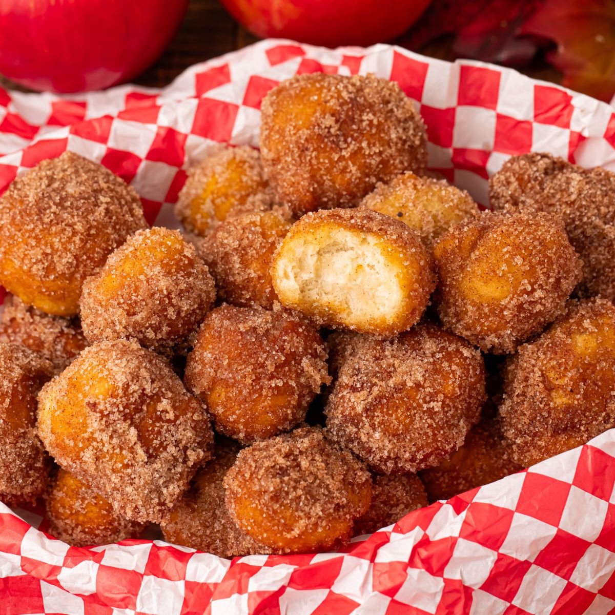 Apple Pie Donut Holes in a basket with a checked parchment paper in basket