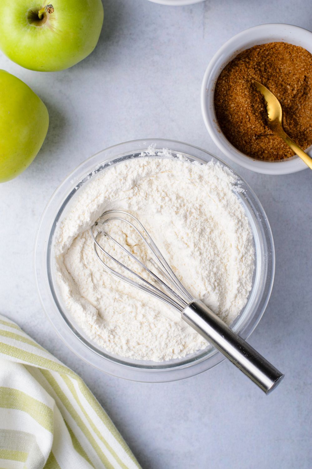 dry ingredients in a bowl for making amish bread and a bowl of cinnamon sugar mixture to side in another bowl 