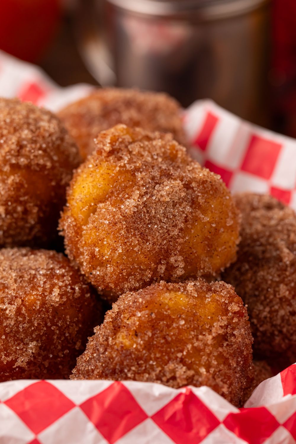 close up look of Apple Pie Donut Holes in a basket sitting on a table 