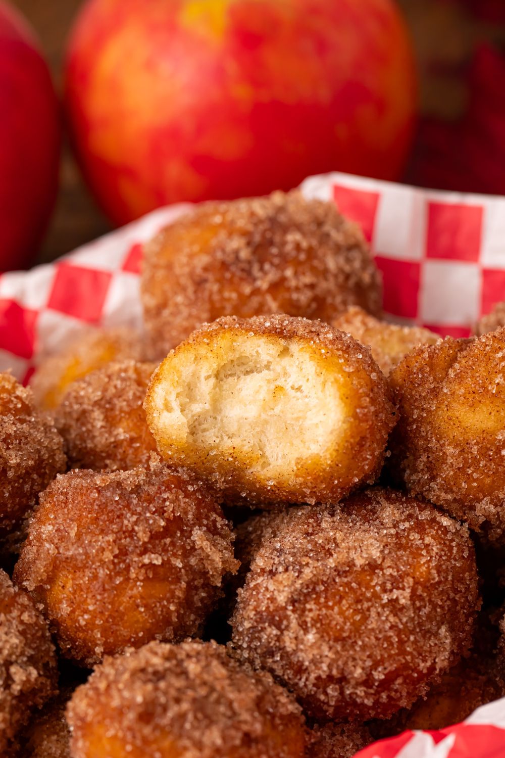 plastic basket with Apple Pie Donut Holes inside and red apples to side of basket