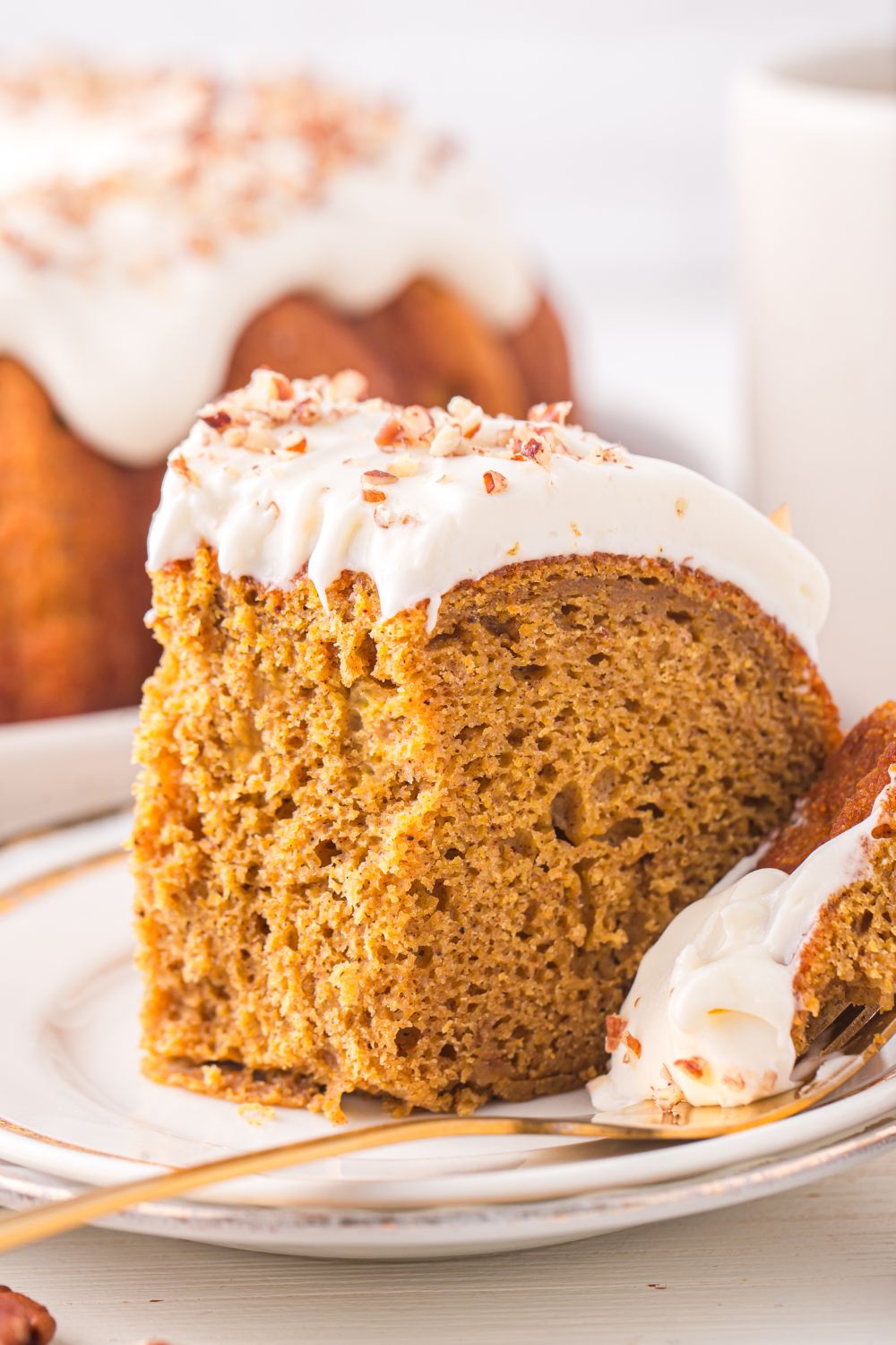 Pumpkin Bundt Cake on a white plate with some of the cake on the silver fork beside it 