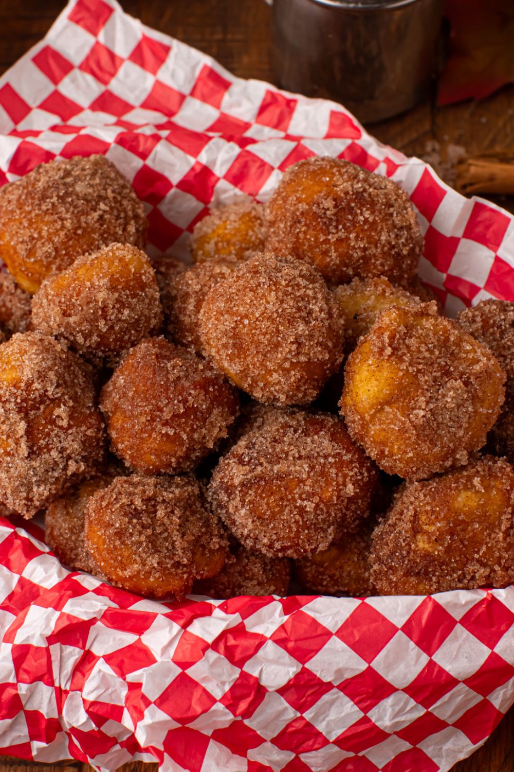basket with a red checkered liner inside full of a bunch of Apple Pie Donut Holes 