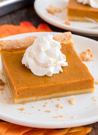 Sheet Pan Pumpkin Pie slice on a white plate on a dark wood table