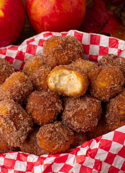 Apple Pie Donut Holes in a basket with a checked parchment paper in basket