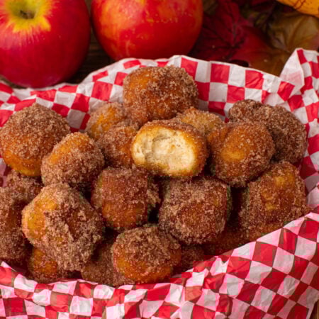Apple Pie Donut Holes in a basket with a checked parchment paper in basket