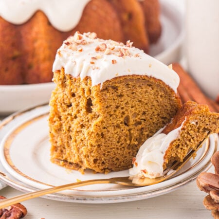 Pumpkin Bundt Cake with Cream Cheese Frosting on a white serving plate