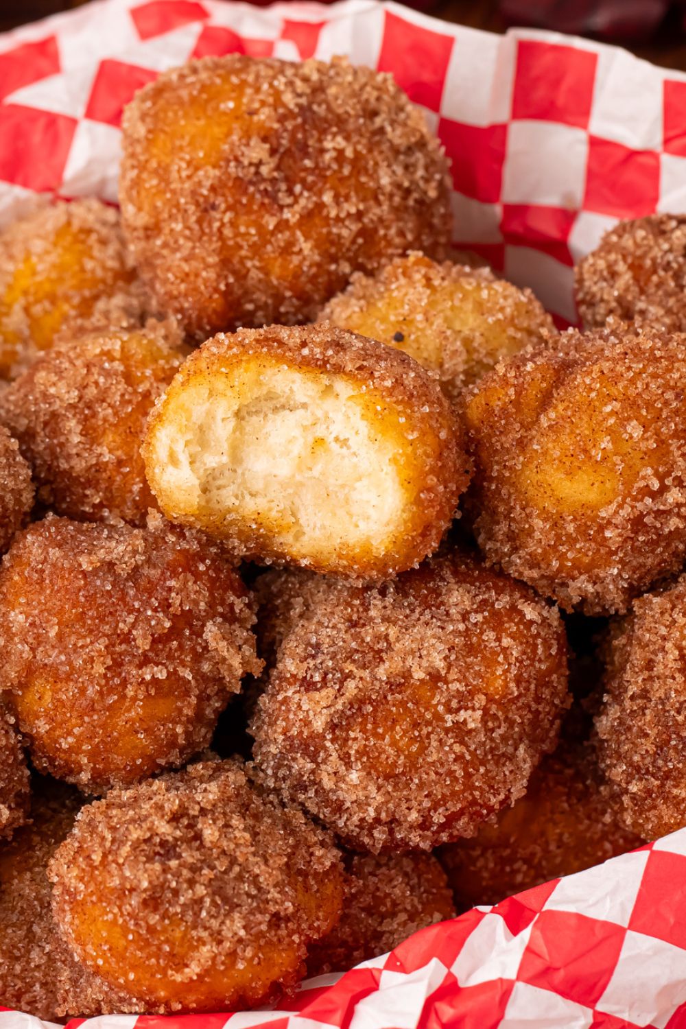 Apple Pie Donut Holes in a basket with a red checked liner sitting on a wooden table 