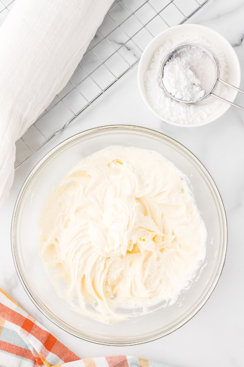 cream cheese filling in a glass bowl sitting on a marble counter 