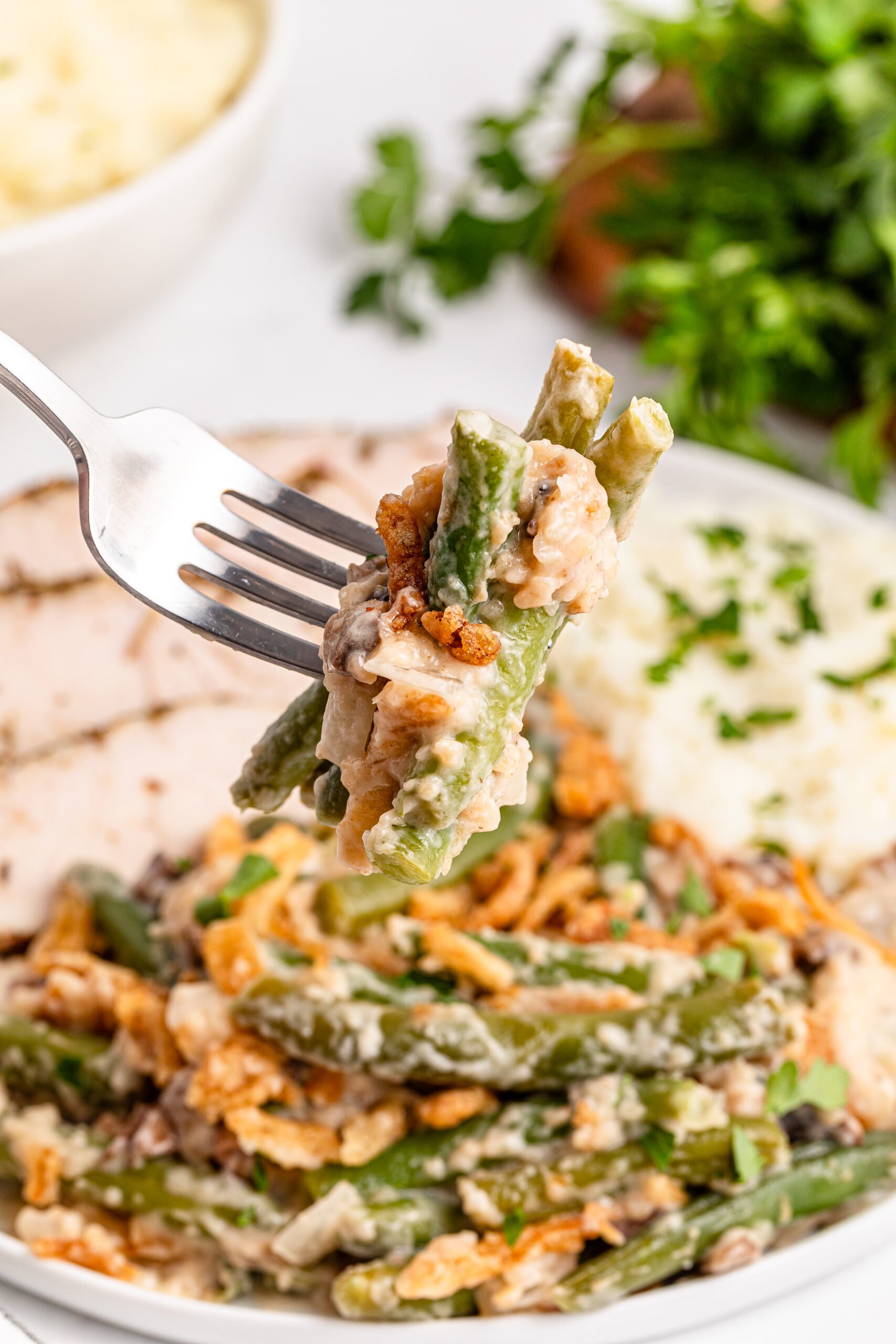 a fork holding up a big bite of the Best Ever Green Bean Casserole