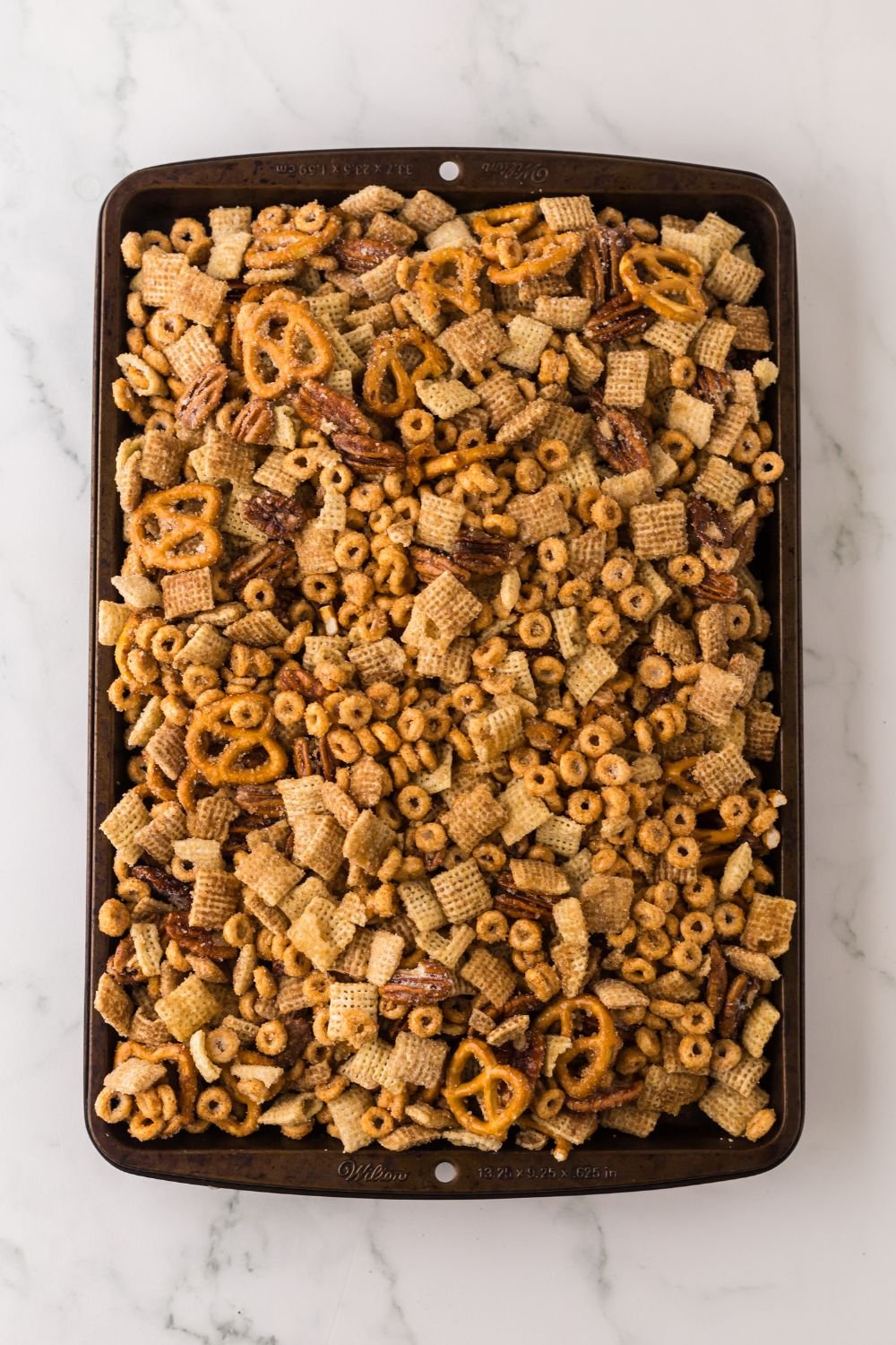 sheet pan full of Pumpkin Spice Chex Mix on a marble counter 