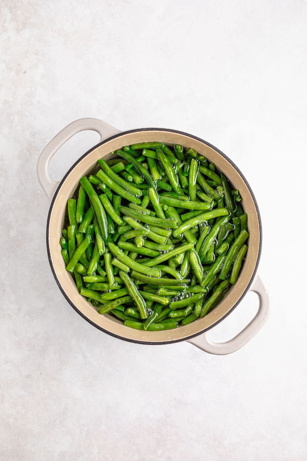 fresh green beans in a pot sitting on a table