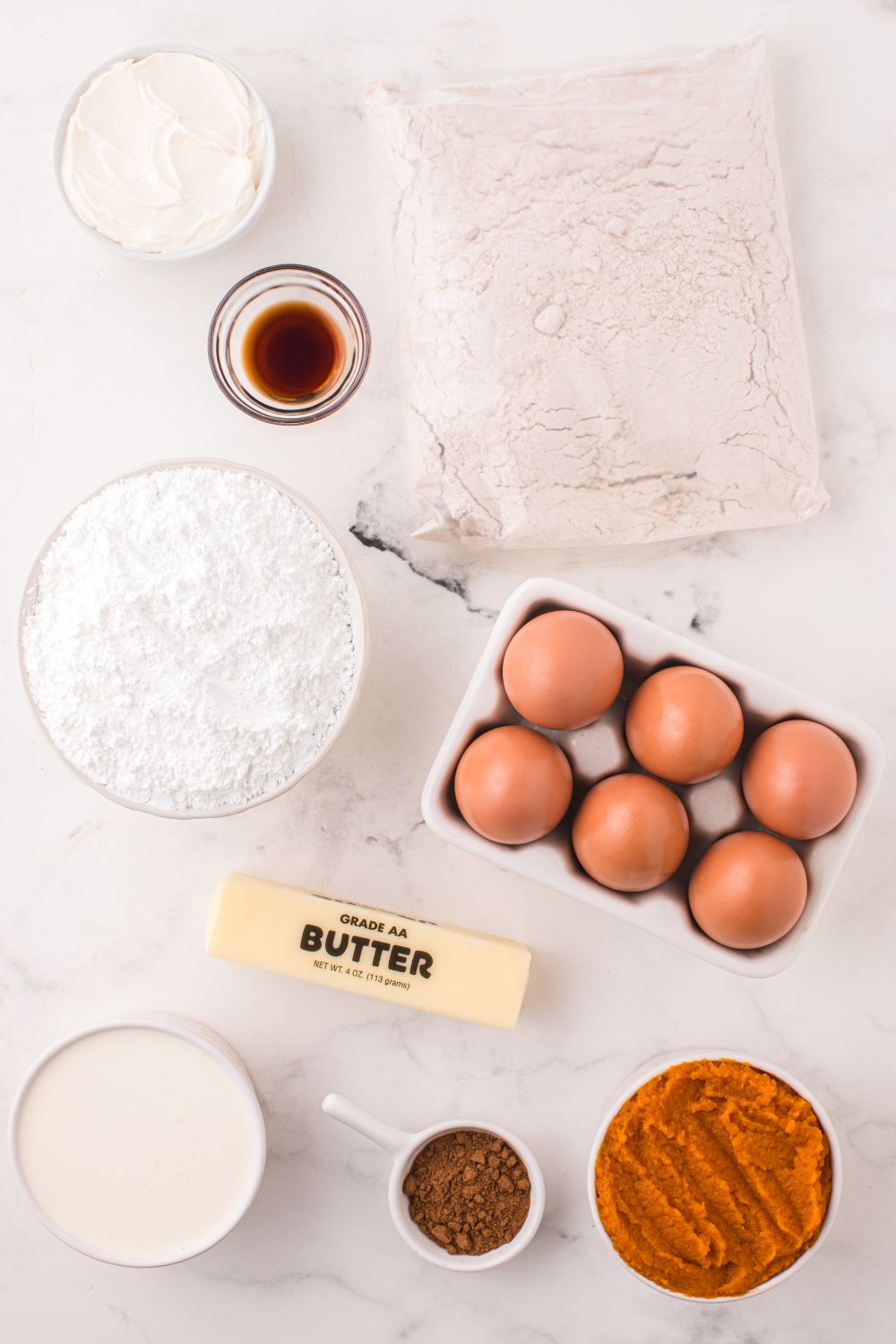 all the ingredients for Pumpkin Bundt Cake on a white table 