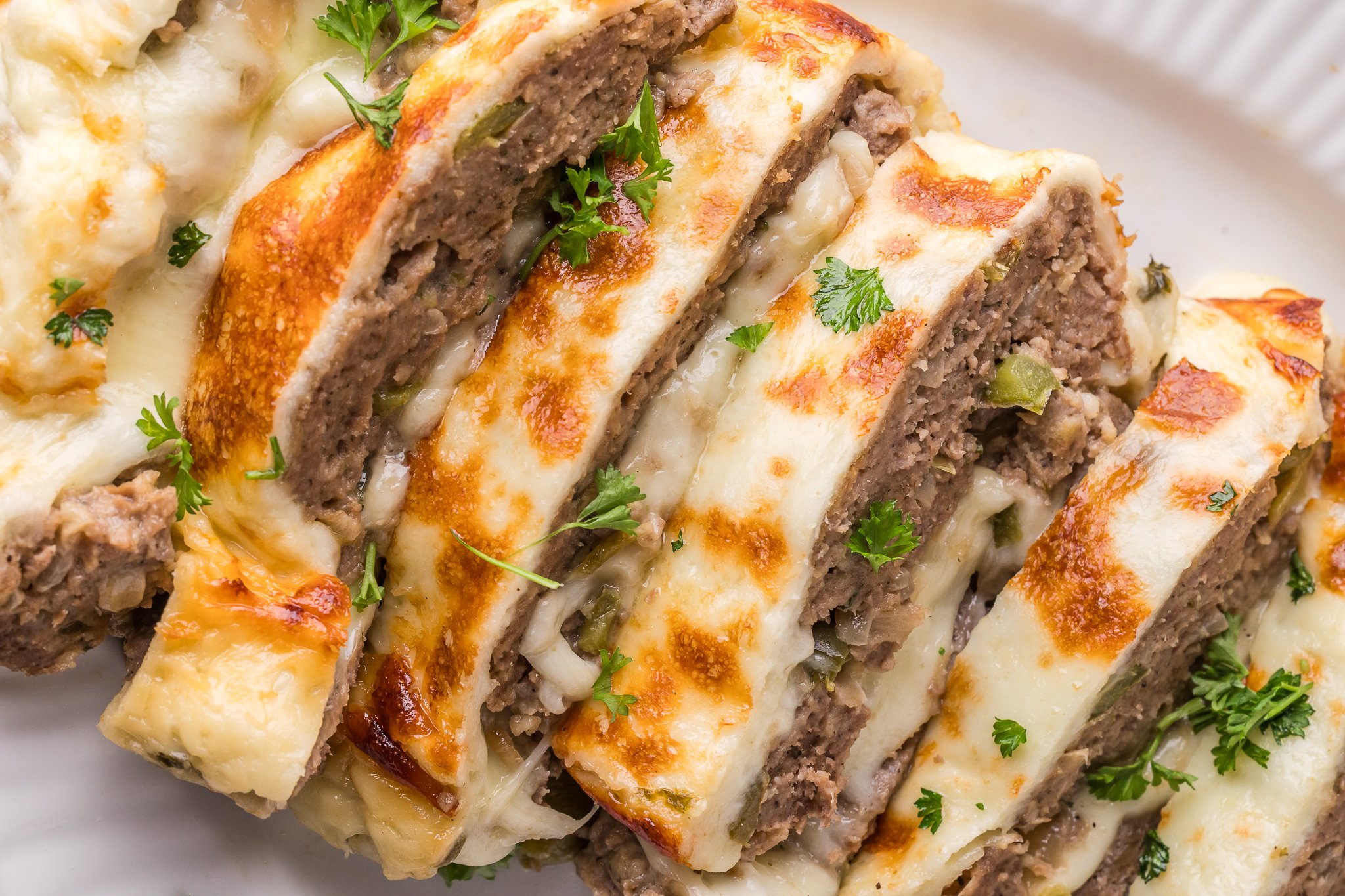 Philly Cheesesteak Meatloaf sliced on a white serving plate 