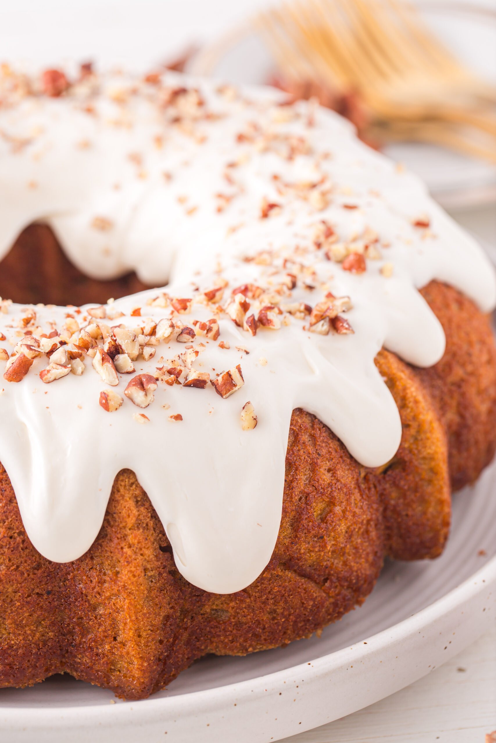 Pumpkin Bundt Cake uncut on a white serving dish 