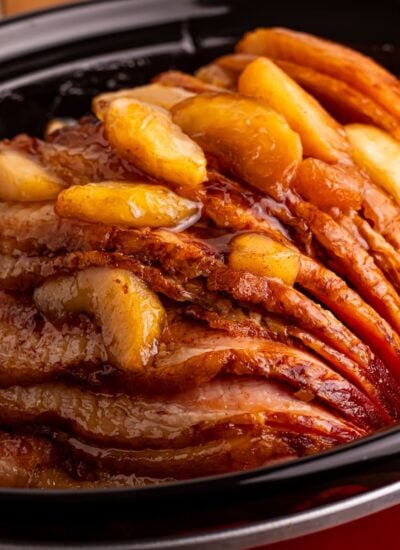 Slow Cooker Apple Glazed Ham in a red crockpot sitting on table