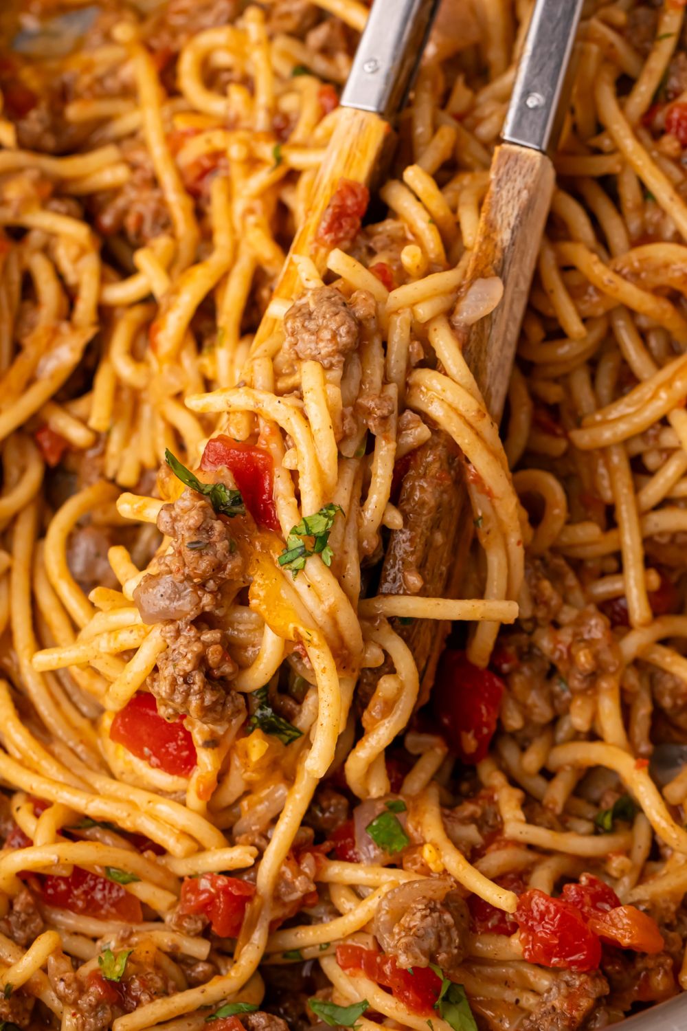 Tex-Mex taco pasta in a pan with tongs full of some of the pasta mixture