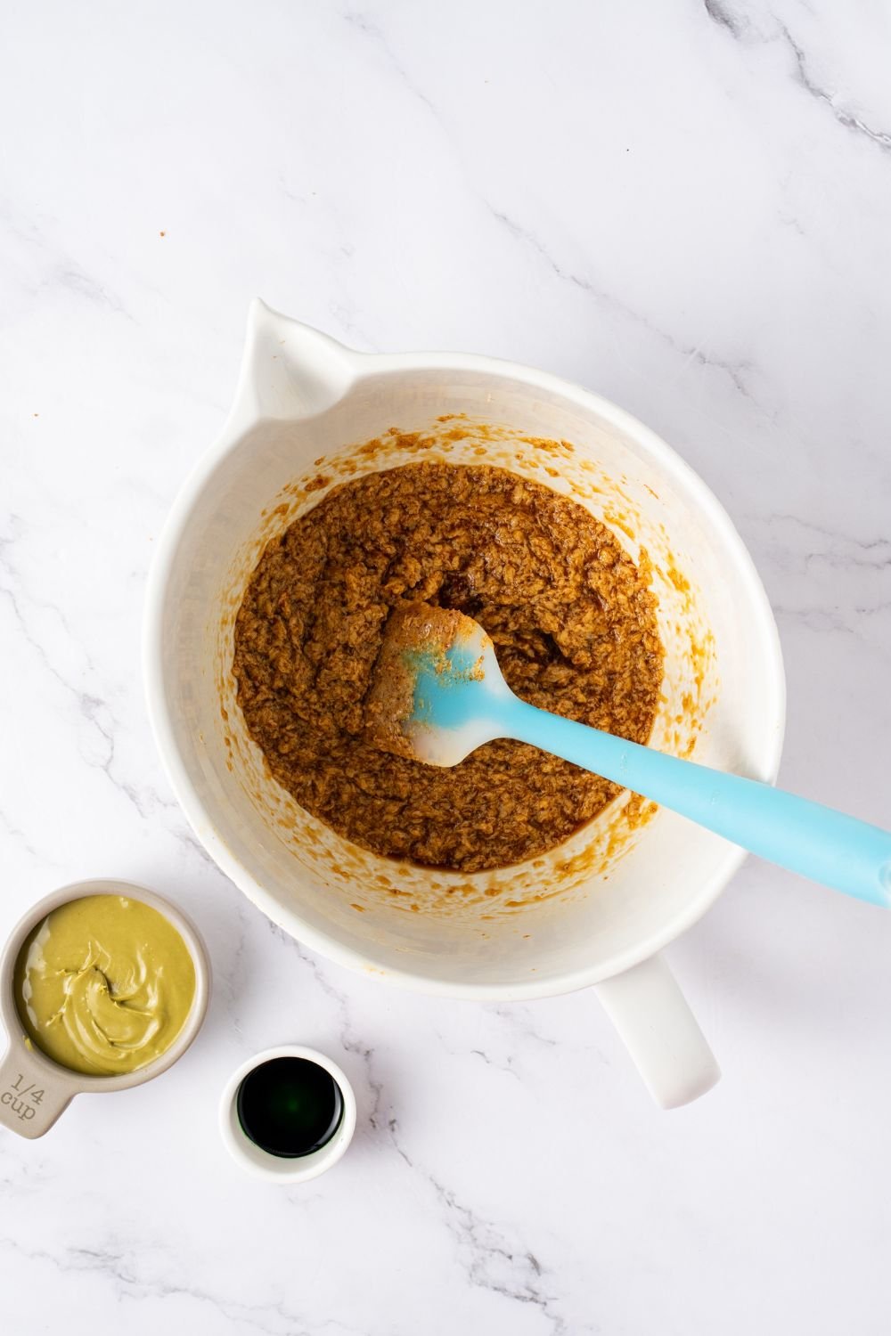 cookie dough batter in a bowl being mixed together with a blue and white spatula 