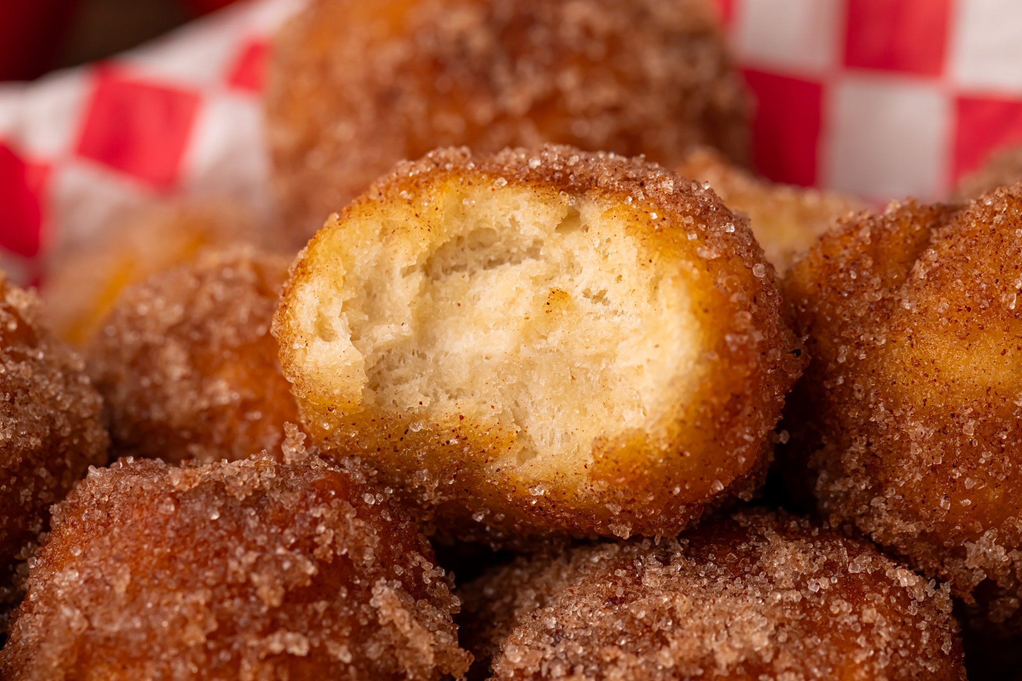 Apple Pie Donut Holes piled in a platter with a bite missing from the top one 