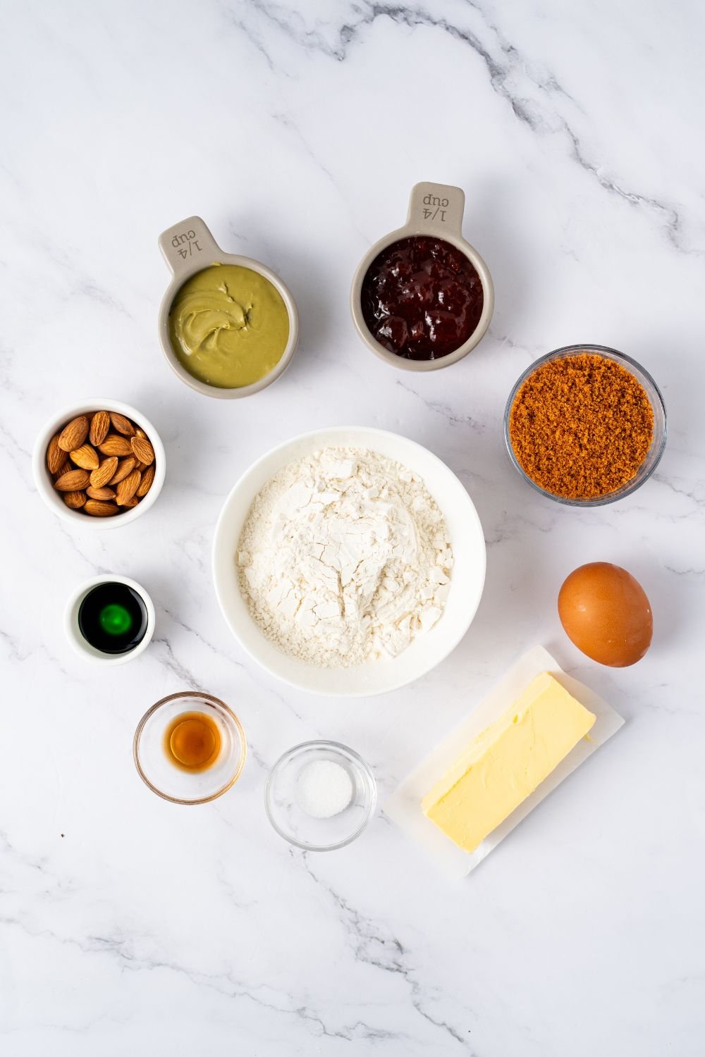 ingredietns for Witch Finger Cookies in single serve containers on a marble counter 