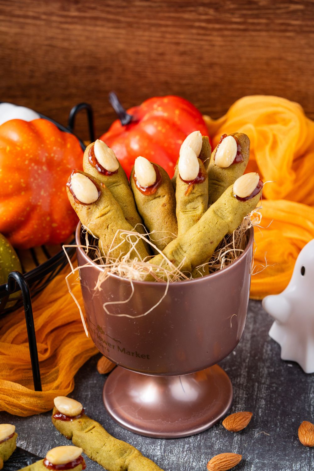 Witch Finger Cookies in a metal container in the center of a table that is decorated for Halloween 