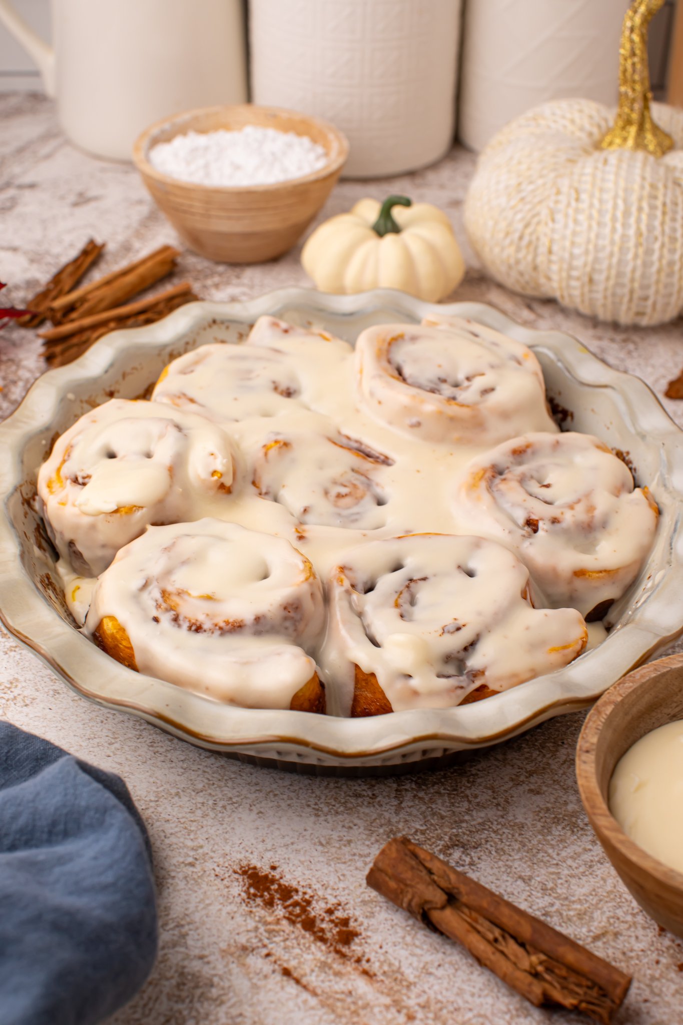 Easy 2 Ingredient Pumpkin Cinnamon Rolls in a baking dish smothered in icing 