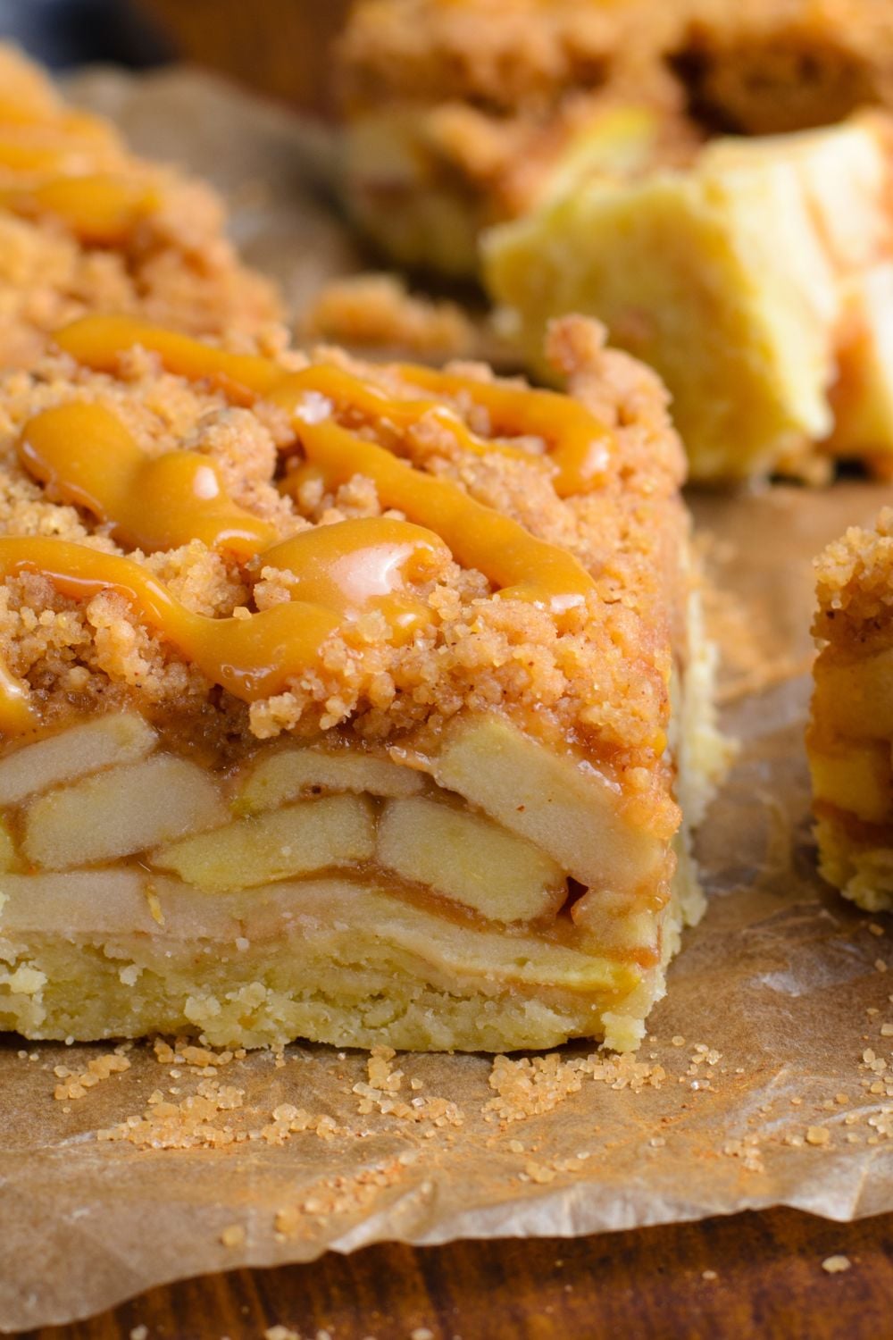 Caramel Apple Pie Bar placed on parchment paper showing apples in the center of the bars 