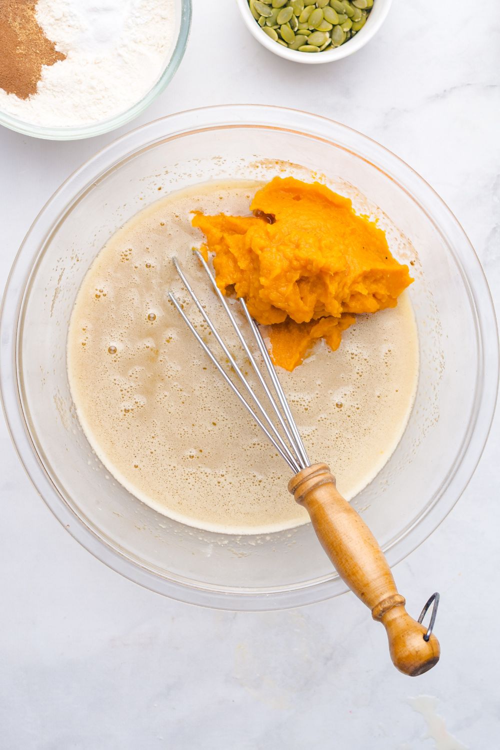 we batter for Starbucks Pumpkin Bread in a glass bowl with a pile of pumpkin puree to side in bowl 