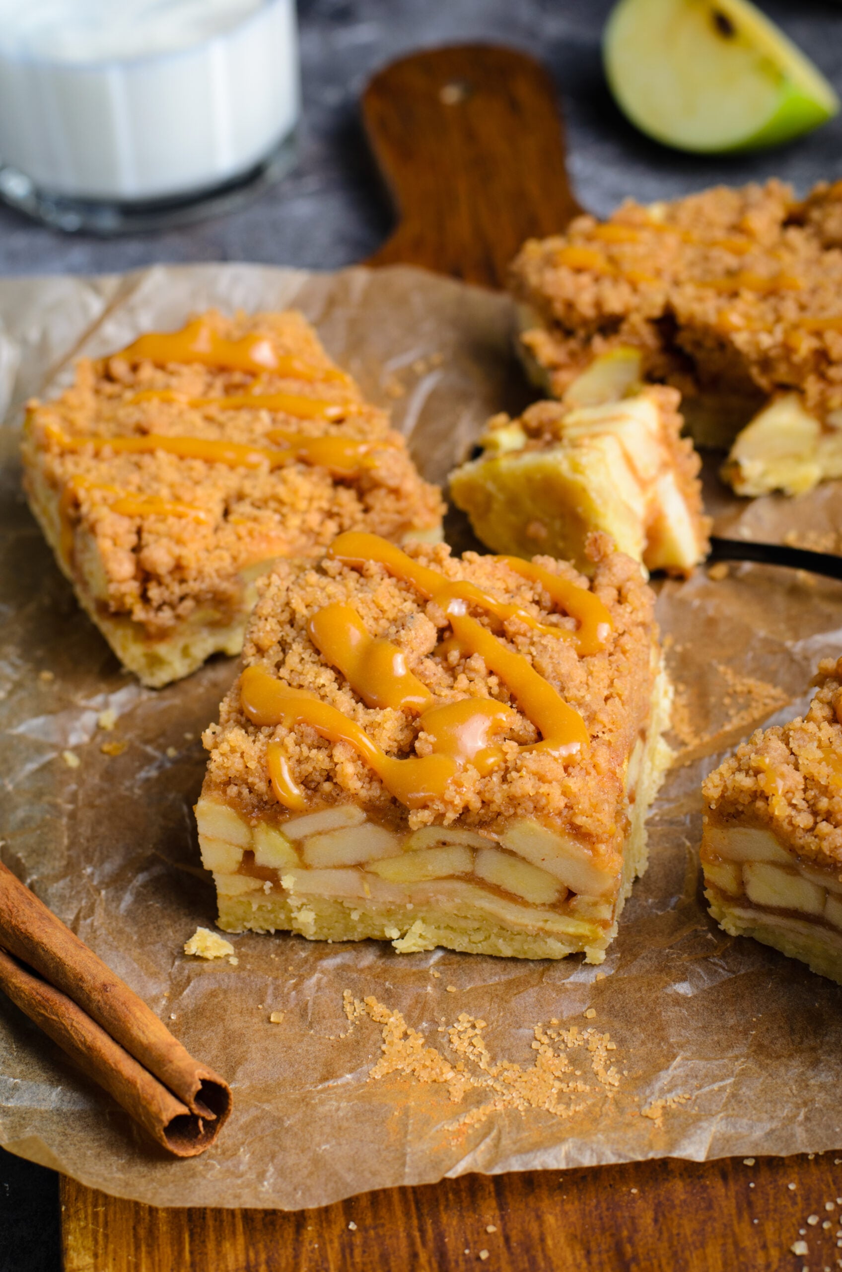 Caramel Apple Pie Bars on placed on brown parchment paper showing apples in the center of the bars 