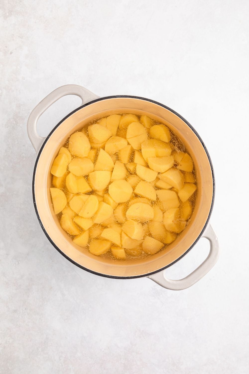 peeled and diced potatoes in a pot with water sitting on the table