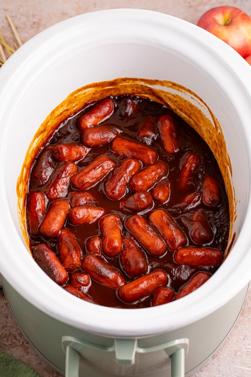 apple butter bbq lil smokies in a white crockpot on the table 