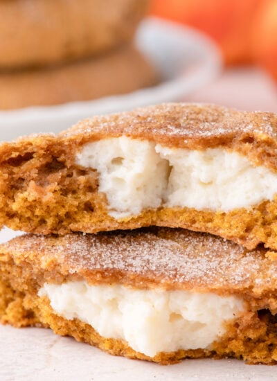Pumpkin Cheesecake Cookies stacked and cut open to show filling