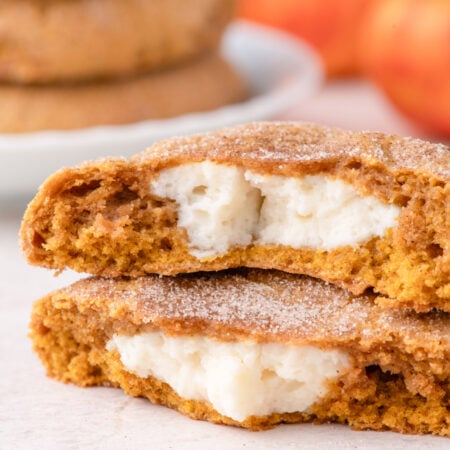 Pumpkin Cheesecake Cookies stacked and cut open to show filling