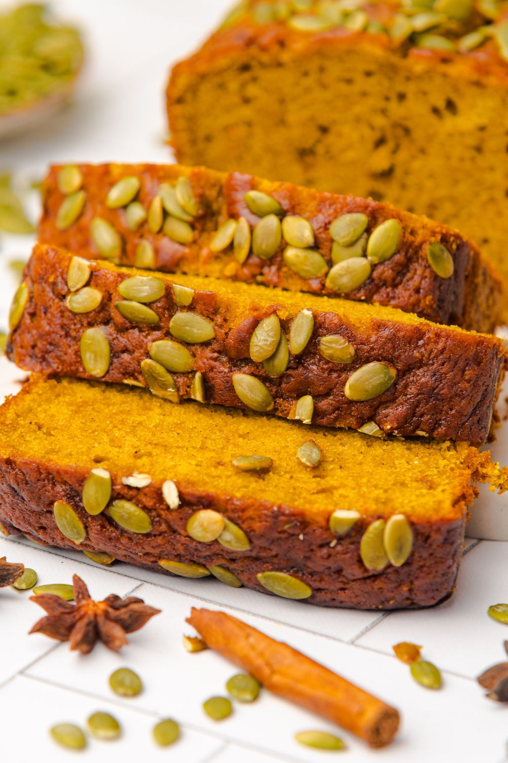 close up look of slices of homemade Starbucks Pumpkin Bread sitting on a white table 