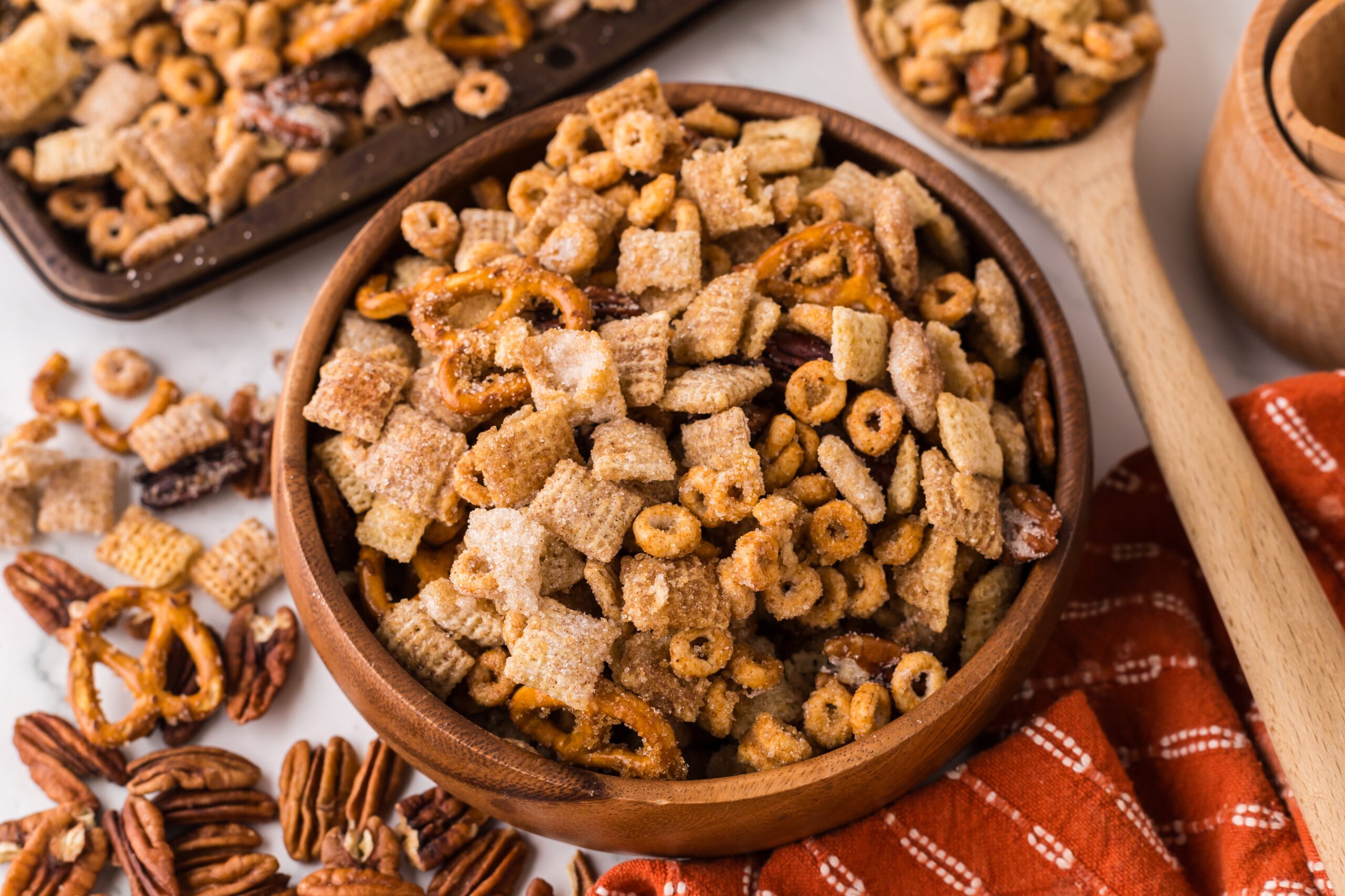 Pumpkin Spice Chex Mix in a wooden serving bowl on a white marble table