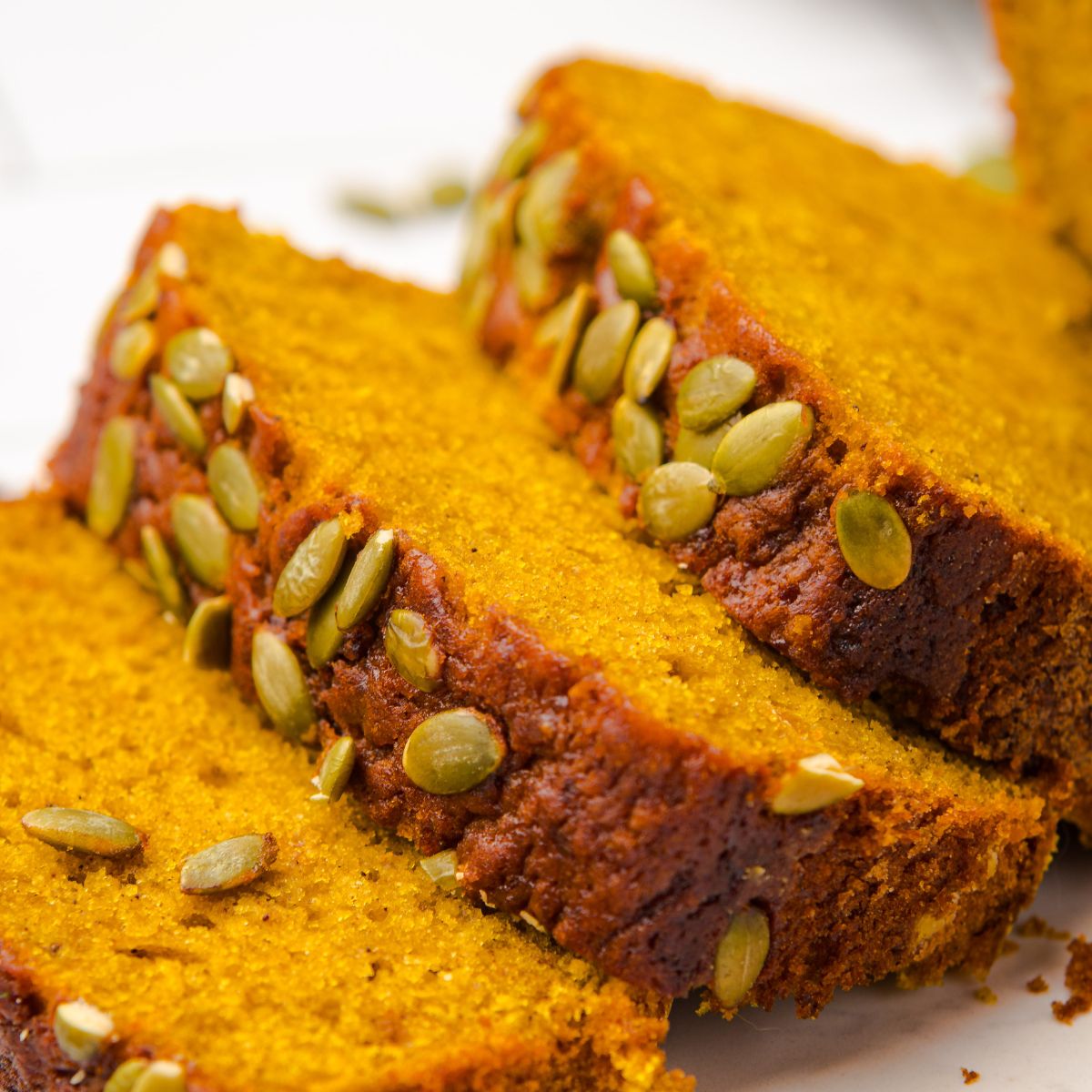 Starbucks Pumpkin Bread   sliced and placed on table with pumpkin seeds on top of each loaf 