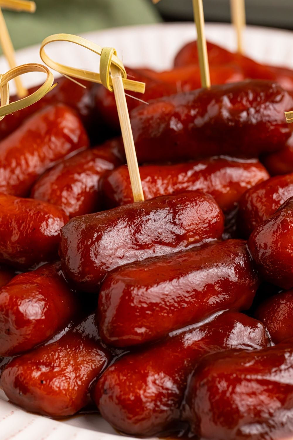 toothpicks poked into saucy lil smokies on a white platter 