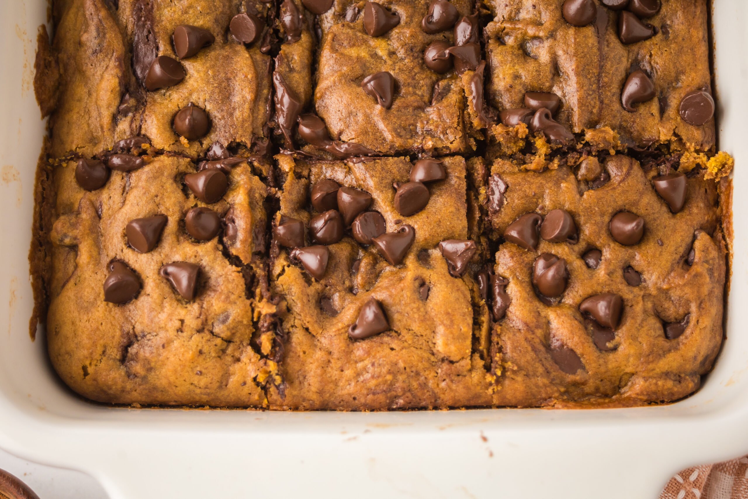 Brown Butter Pumpkin Chocolate Chip Bars in a white baking pan sliced 