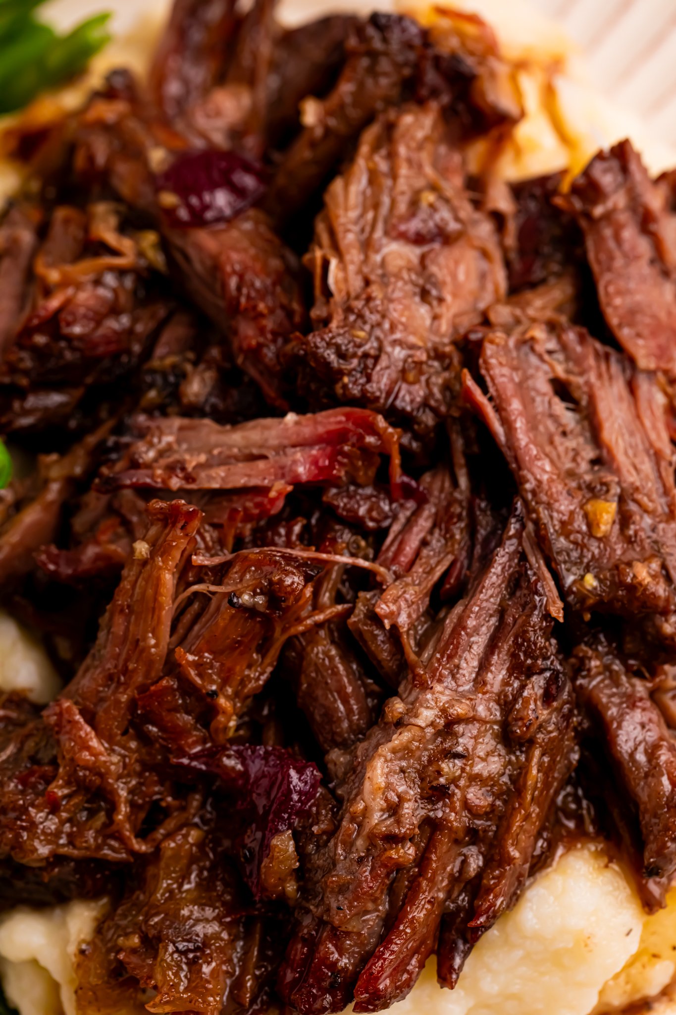 Up close shot of the Cranberry Pot Roast shredded on a white plate 