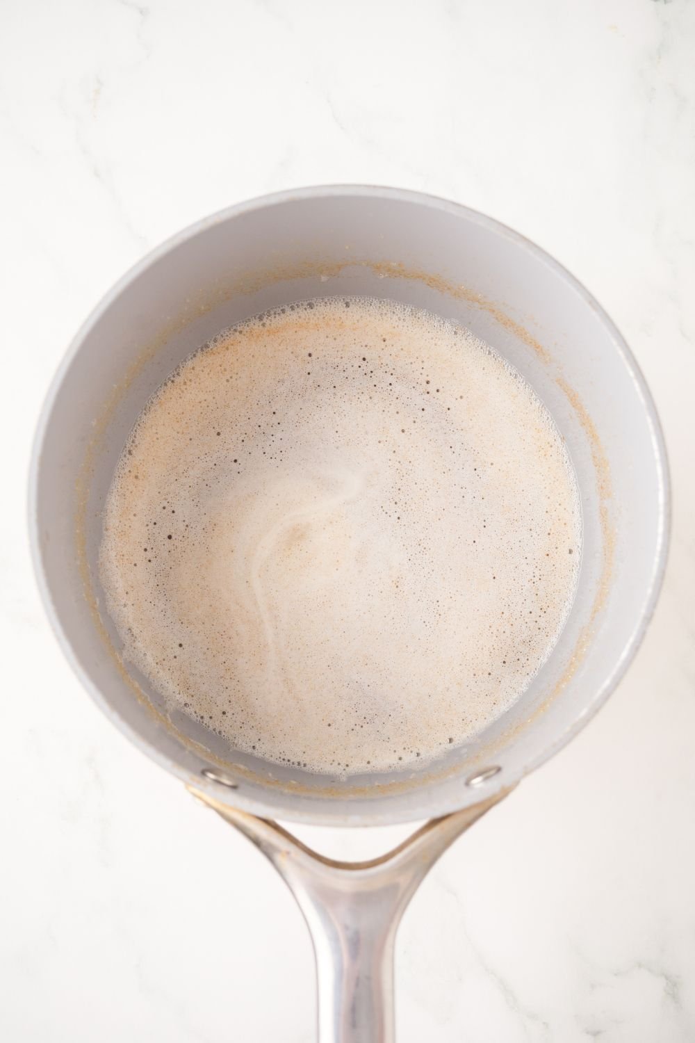brown butter in a metal sauce pan sitting on the table 