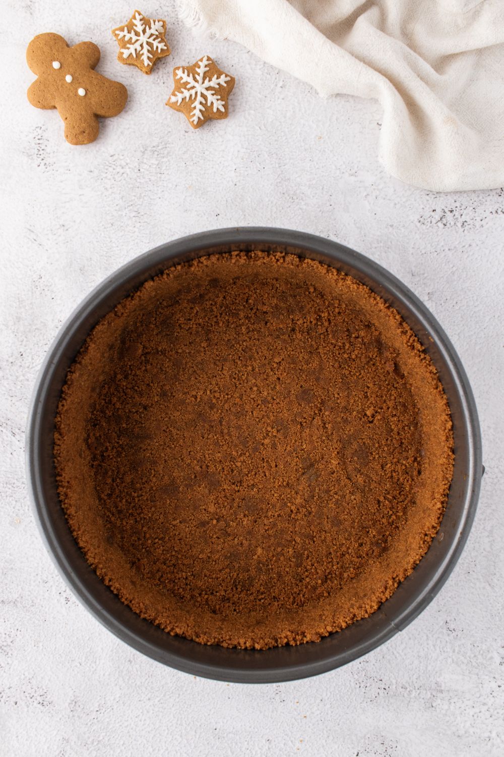 gingerbread cheesecake crust in pie pan on table 