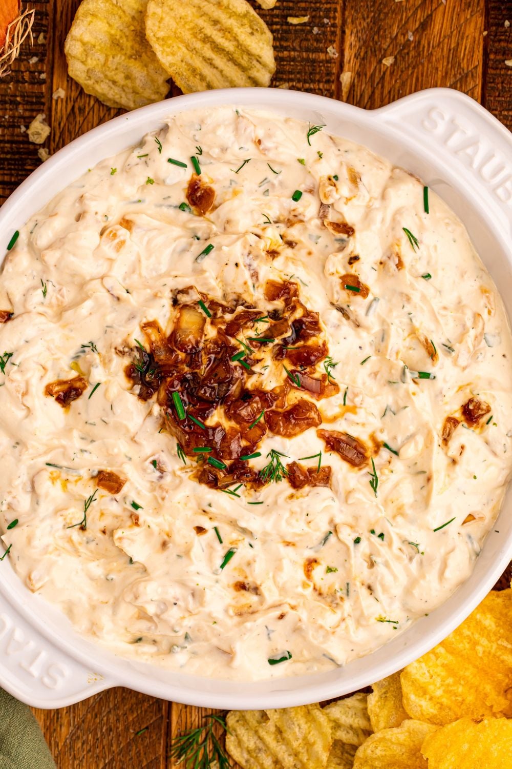 looking down on table for a bowl of onion dip with ruffle chips around the table 