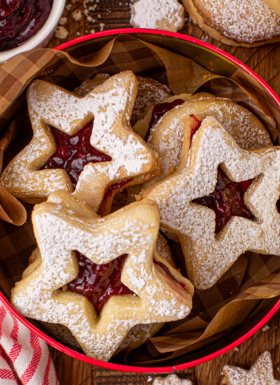 a Christmas cookie tin filled with Linzer Cookies with Jam Filling