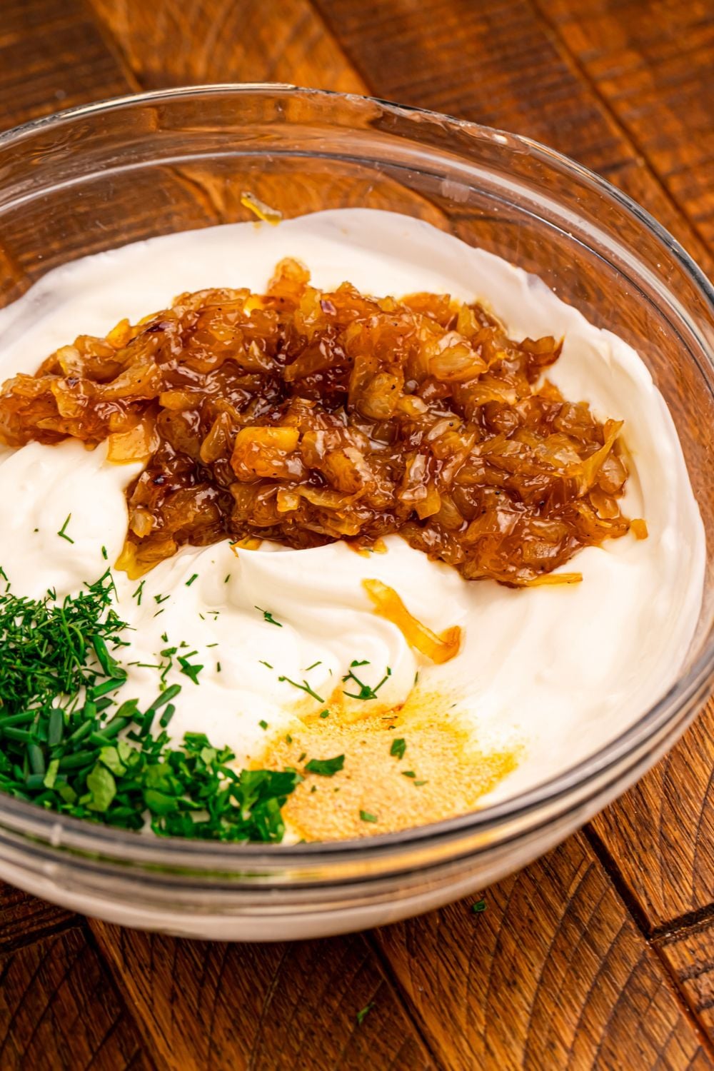 glass bowl of caramelized onion, herbs, garlic and more 
